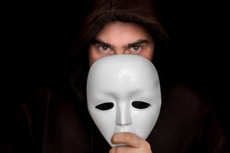 A threatening person hides partially behind a mask