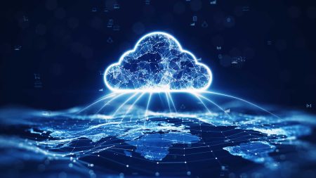 Cloud computing concept - an interdependent cloud is positioned overa map of the world with data moving backwards and forwards.