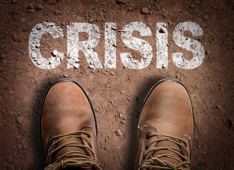 crisis management: the word crisis with two feet ready to walk through it