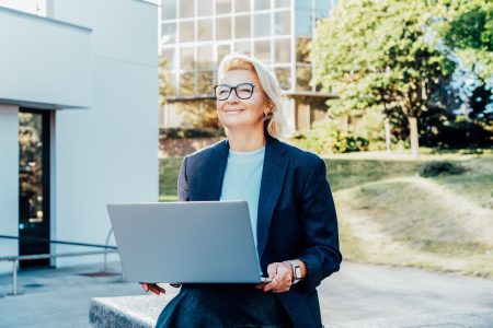 The cyber resilient CEO - the image shows a female CEO holding a laptop and looking confident