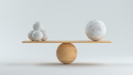 concept shows wooden scale balancing one big ball and four small ones.