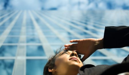 Survey report highlights the ‘Risk and Resilience Outlook’ for UK financial services sector Looking ahead concept: a woman stands under a high-rise building while scanning the horizon