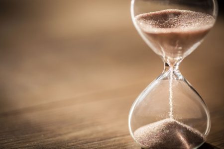 AFME warns that DORA deadlines are not realistic and risk causing disruption Sand running through the bulbs of an hourglass measuring the passing time in a countdown to a deadline.
