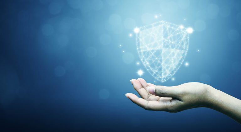 A business person holds a hand out and holds a futuristic shield.