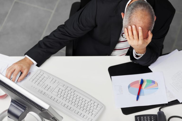 human error - Resilience Forward An employee holds his head in his hands after accidentally launching malware on his computer.