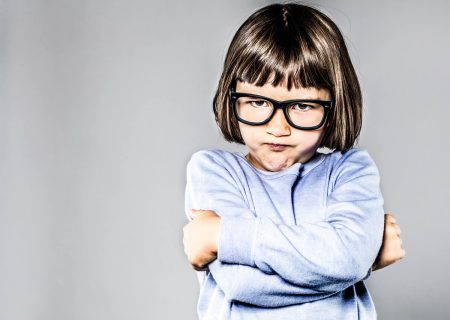 The importance of body language in crisis communications Body language: a child shows her mood by crossing her arms tightly around her body.