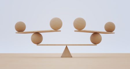 A complicated balanced tower of planks and balls illustrates the need to balance risk and opportunity when it comes to AI chatbots.