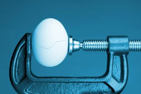 Managing scenario testing for operational resilience Under pressure: An egg cracking under pressure applied by squeezing clamps form the sides.