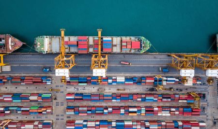A cargo ship being loaded at a port.