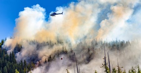 More than half of Canadian businesses were financially impacted by extreme weather in 2023 Helicopter fighting forest fires in Vancouver Island, BC, Canada.
