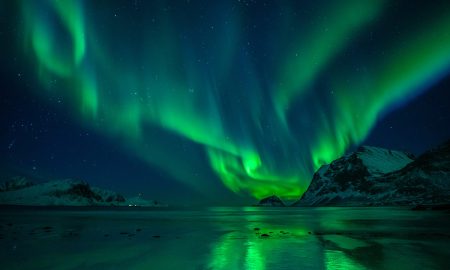 The impact angle of interplanetary shocks is key to the risk of critical infrastructure damage The Northern Lights seen over a beach.