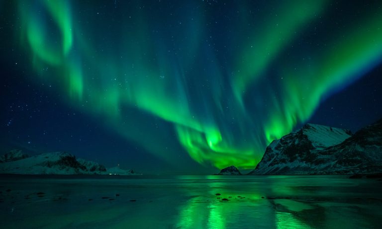 The Northern Lights seen over a beach.