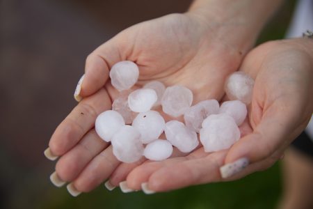 First half of 2024 sees large losses from a high frequency of small to medium natural catastrophes Hands hold large hail from a severe convective storm