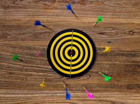 A group of darts all miss the target.