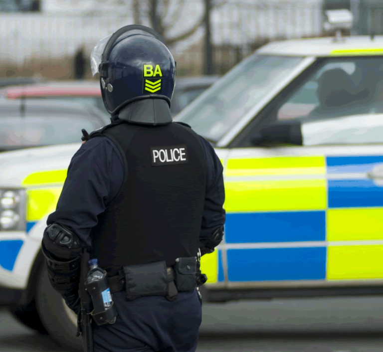 public order - Resilience Forward A police officer stands behind a police car in the UK