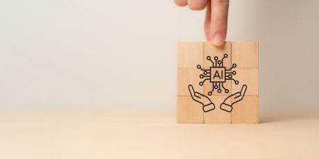 Improving AI risk management: new guidance on governance from the CSA AI governance guidance - two hands hold an AI icon safely.