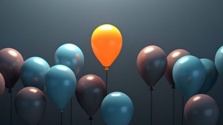 The concept of standing out, leadership, originality, and independence. A bright, vibrant balloon that stands out from the crowd.