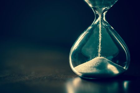 Time running out: an hour glass with a very small amount of sand left to run through...