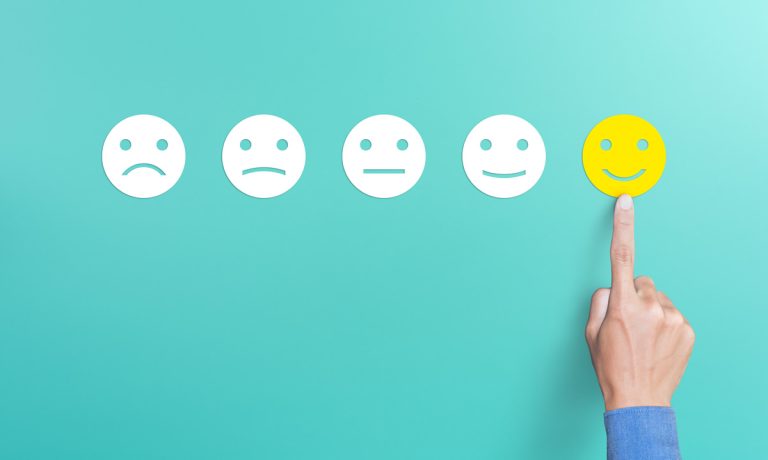 Survey results - a finger points to a smiley icon.