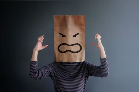 Poor digital experiences are having large business impacts A woman wearing a paper bag on her head with an angry face drawn on it in black marker pen.