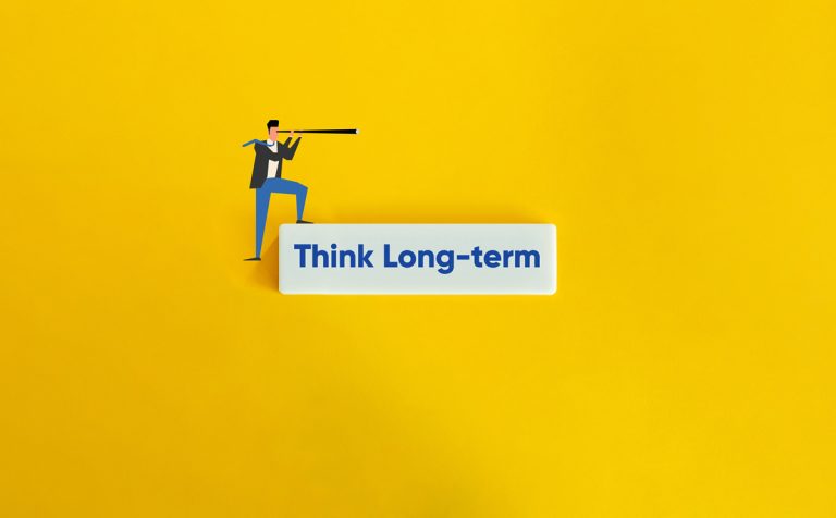 A business person looks through a telescope above a text block stating Think long term.