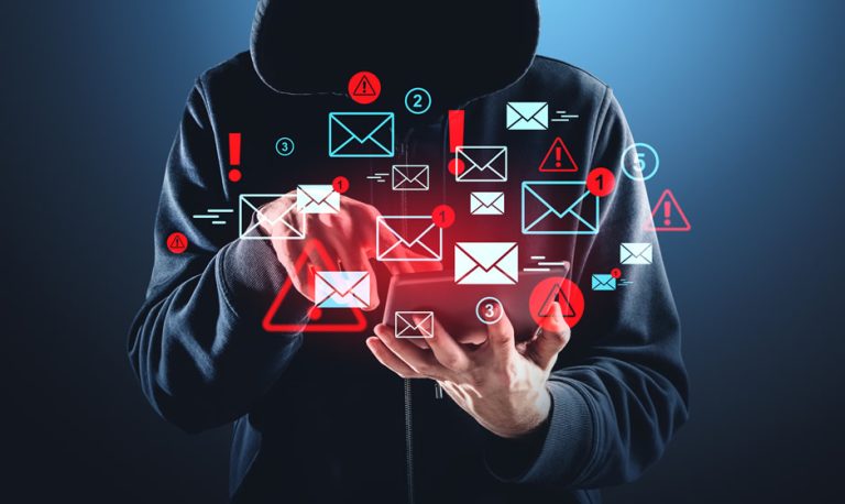 The concept of social engineering attacks shown by a shadowed hacker using a laptop surrounded with communications icons.