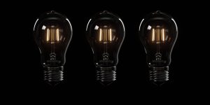 Three dark coloured light bulbs on a black background illustrate the concept of The Dark Triad in Crisis Management.
