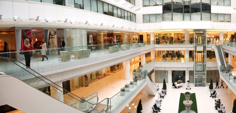 Shoppers walk around an indoor retail environment.