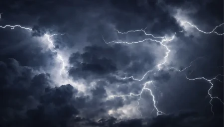 Powerful lightning bolts cutting through dark storm clouds in a night sky.