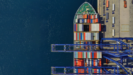 Supply chain resilience is about managing persistent uncertainty – and needs active governance Aerial top down photo of industrial container ship loading .