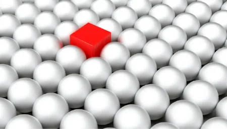 A red cube in a field of white circles.