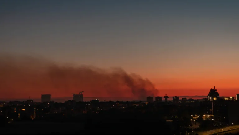 European wildfire - Resilience Forward Smoke from a fire over a night city: a sunset sky in Rome, Italy, with smoke drifting across.
