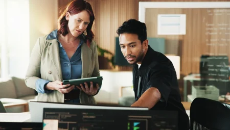 Two worried employees look at an application failure on screen.