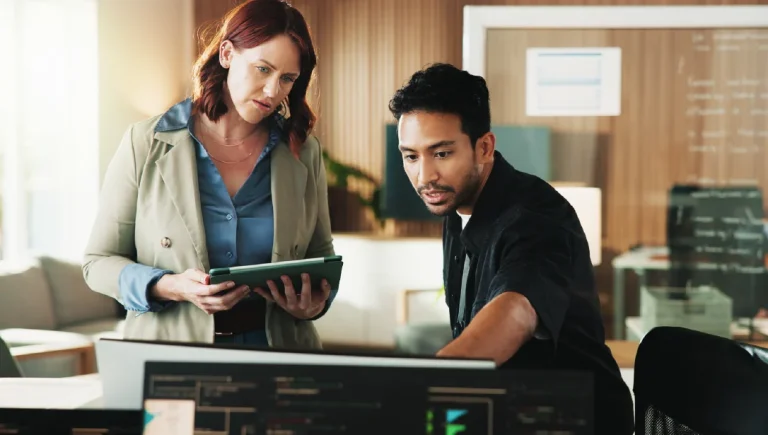 Application incident - Resilience Forward Two worried employees look at an application failure on screen.